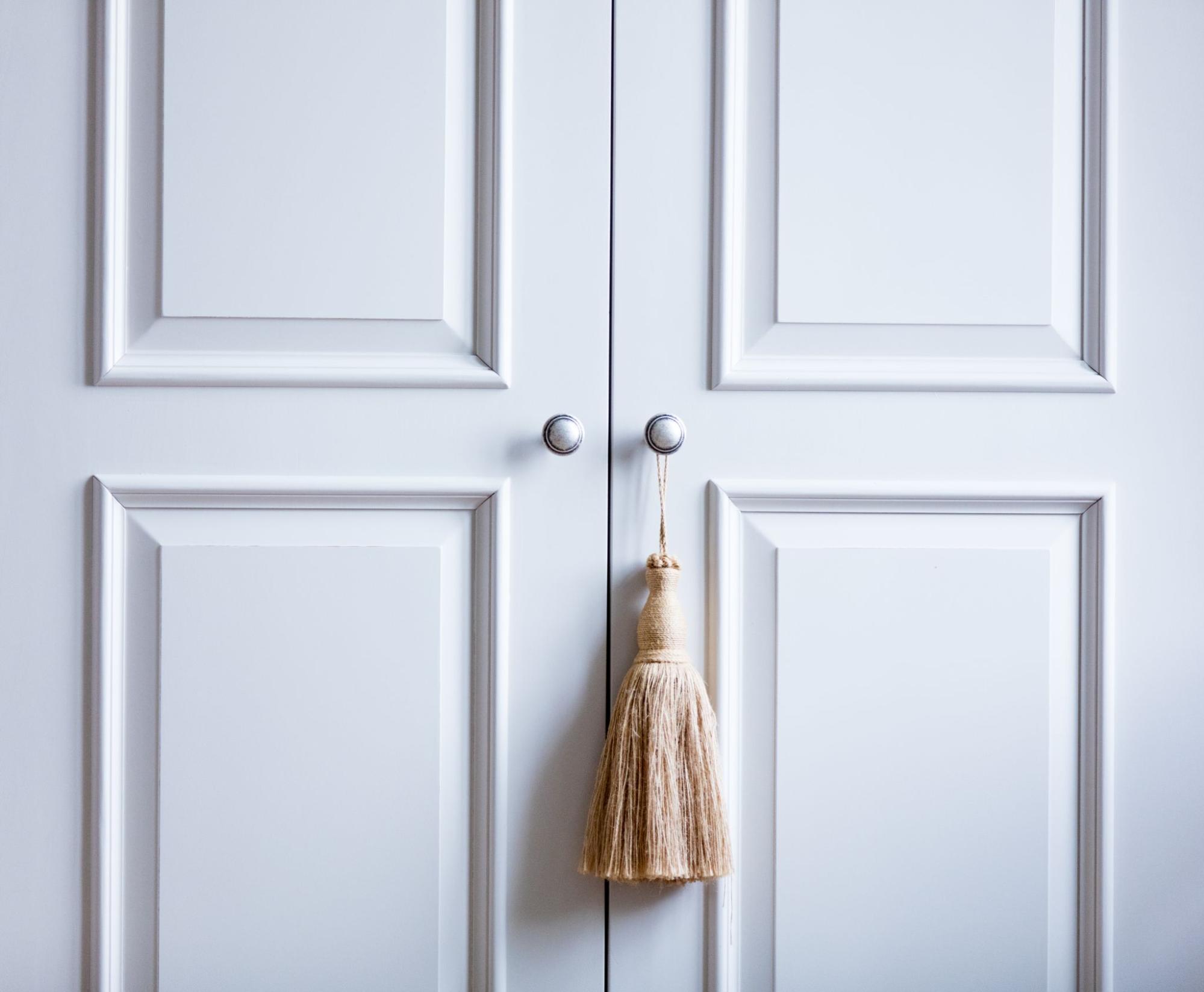 Classic white Shaker-style cabinet doors with a decorative ornament hanging from the knob