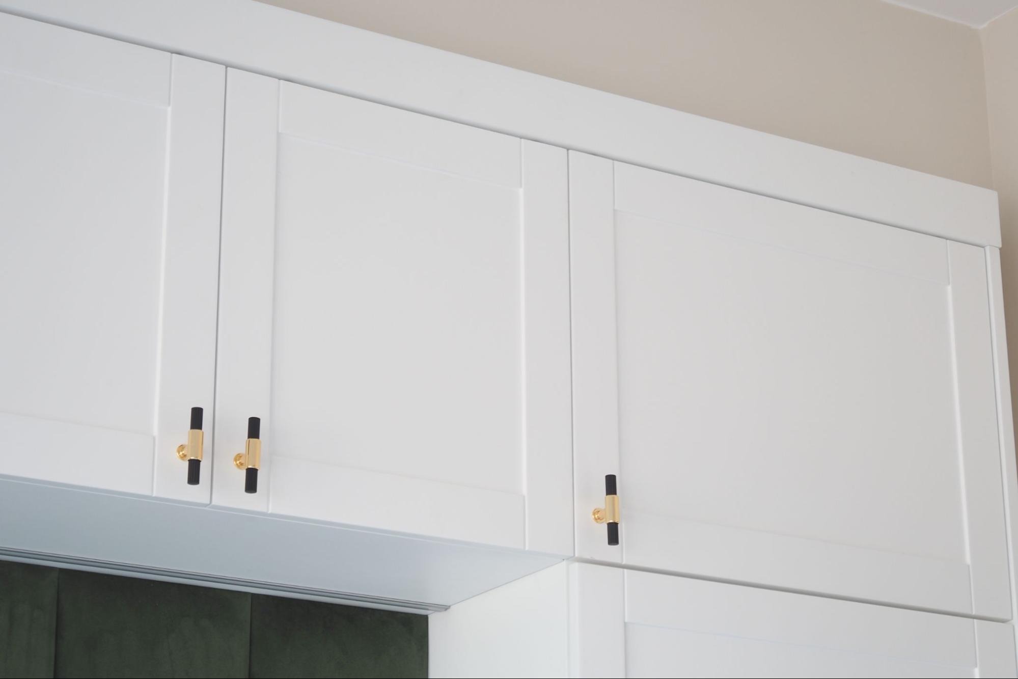 Elegant white Shaker-style upper kitchen cabinets with gold hardware accents