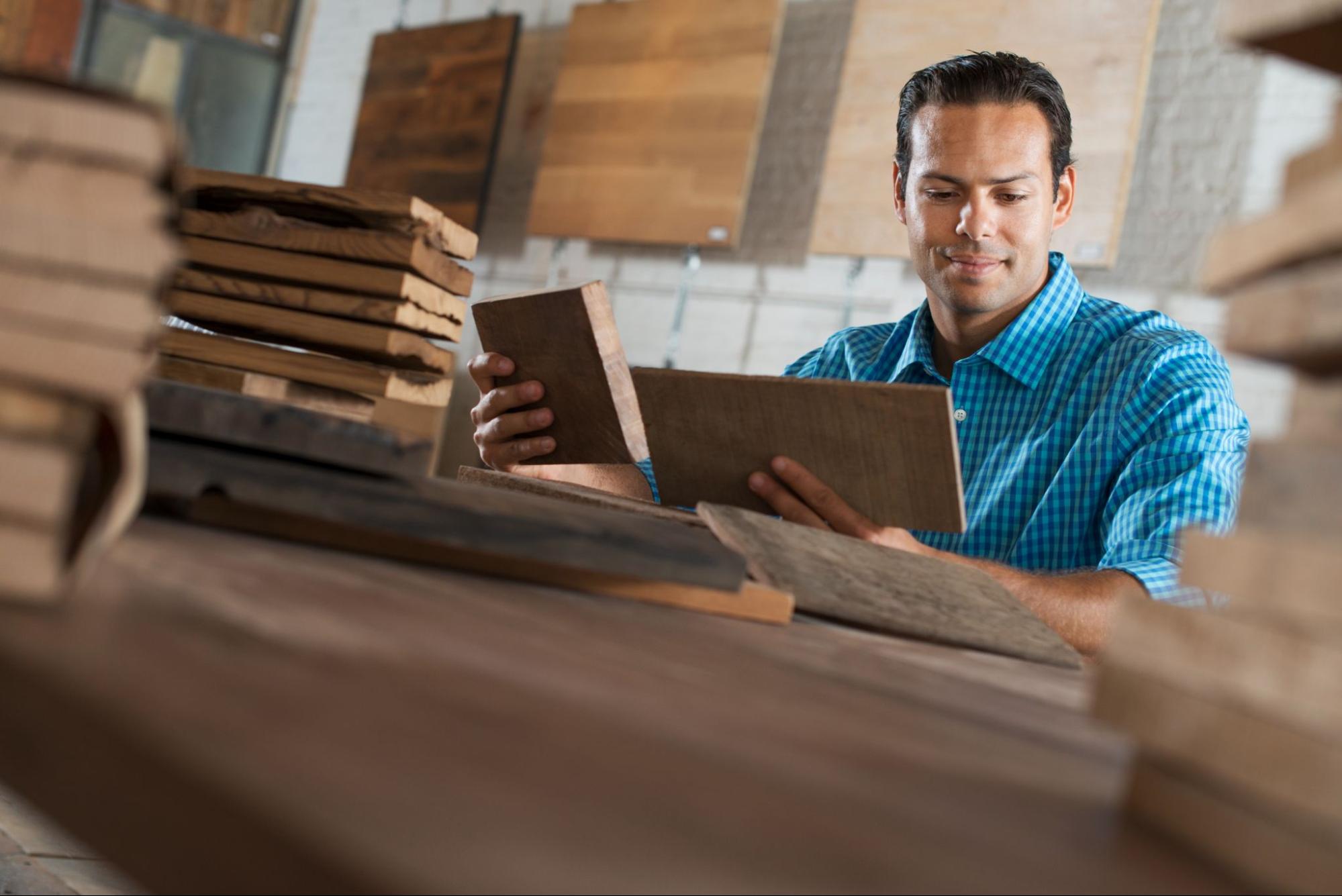 A home designer evaluates two cabinet wood samples to find the best match for the client's vision. 