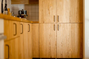 A kitchen interior styled with natural wood-colored cabinets.
