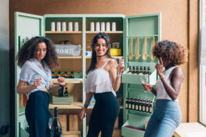 Three young women dance in a kitchen in front of a custom cabinet.